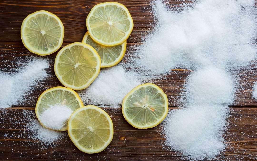Ensemble composé de sel et de tranches de citron sur un fond en bois. Vue de dessus.