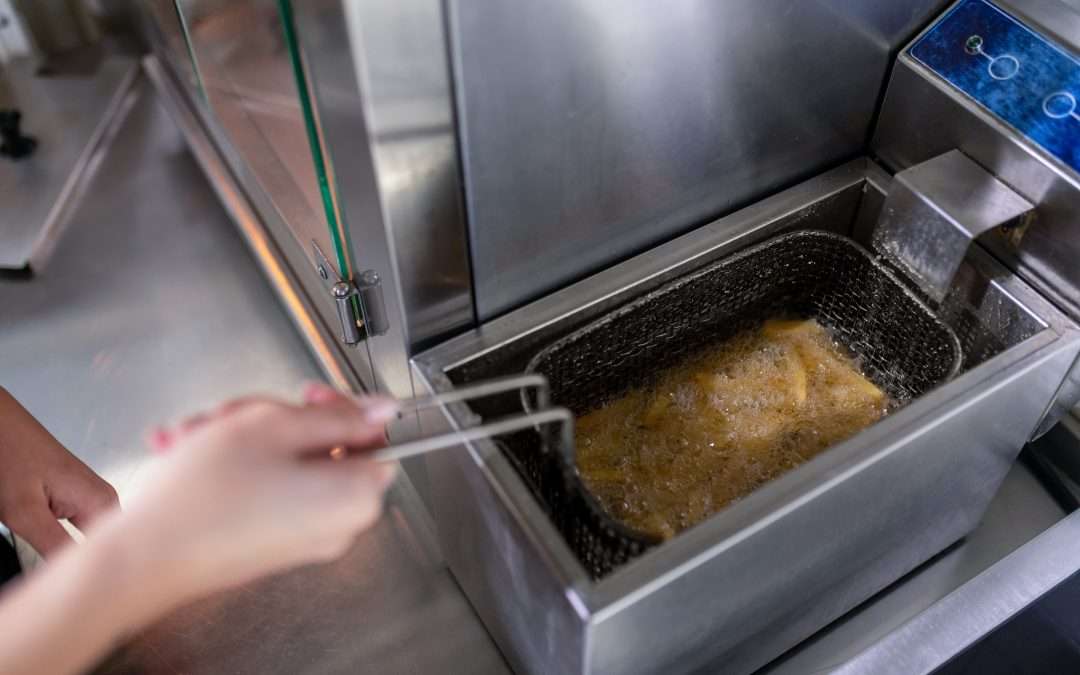 Gros plan sur des mains en train d'utiliser une friteuse