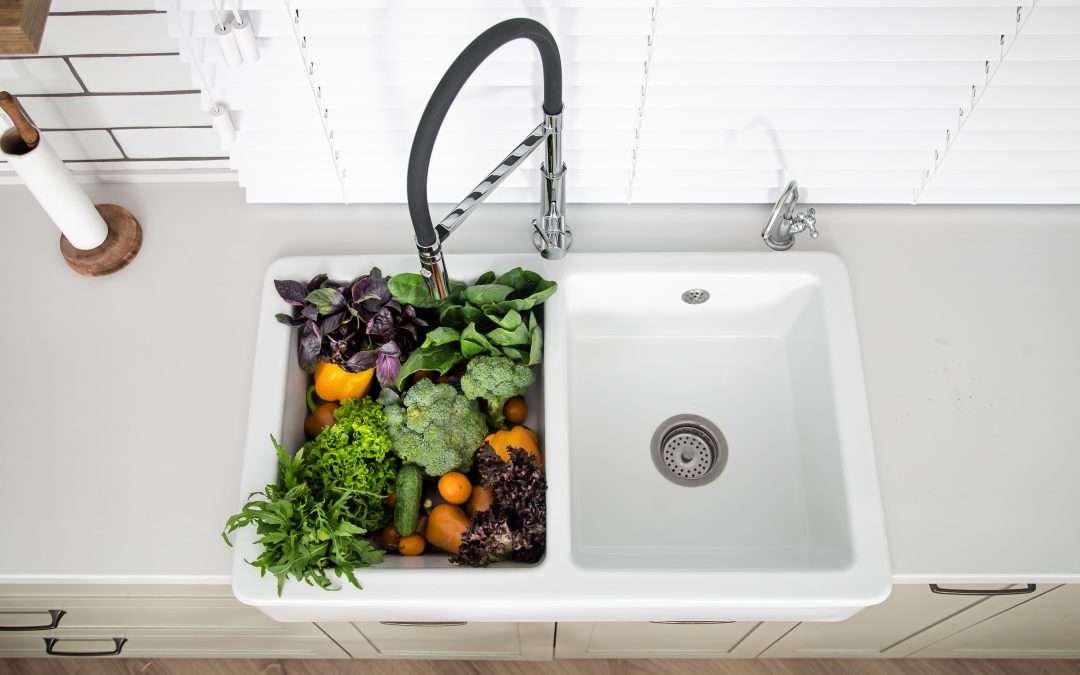 Vue de dessus sur des légumes fraîchement lavés dans l'évier en résine de la cuisine.